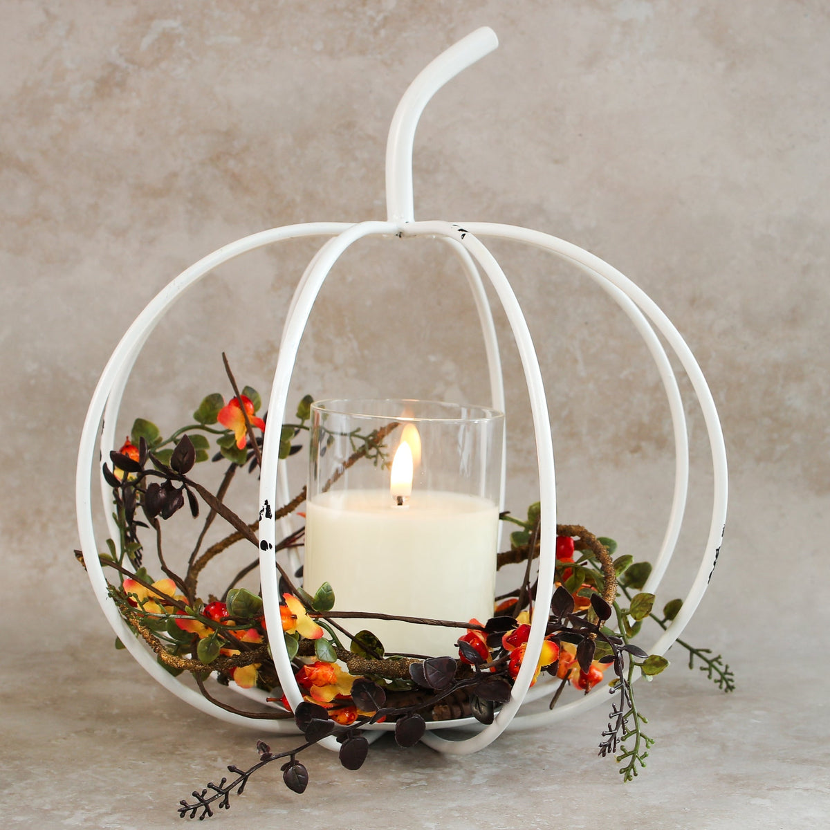 White Metal Cage Pumpkin candle holder adding warmth and rustic charm to home decor.